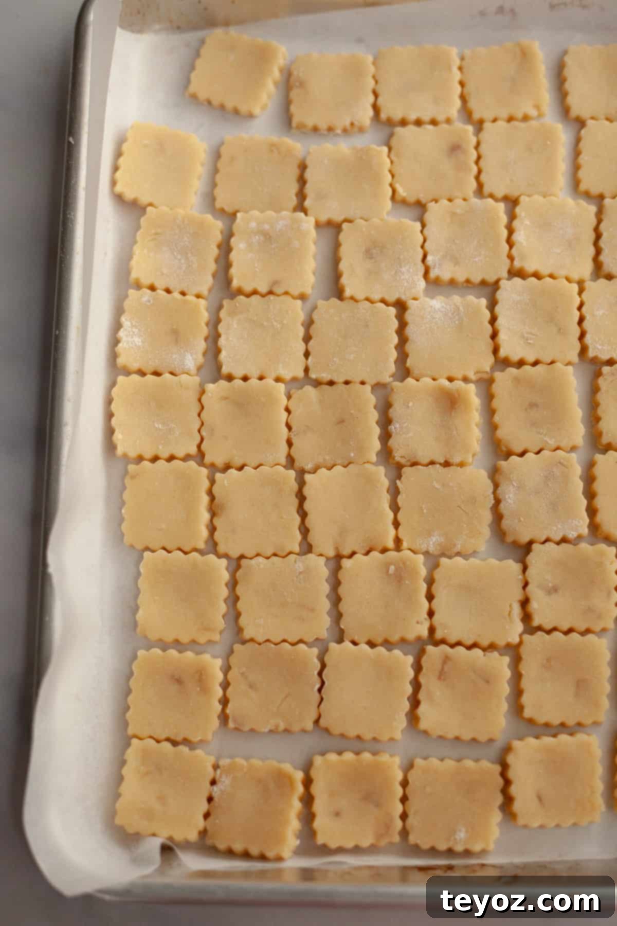 Double the Zing: Ginger Snap Delights 8 Unbaked ginger shortbread cookies arranged on a parchment-lined baking sheet.