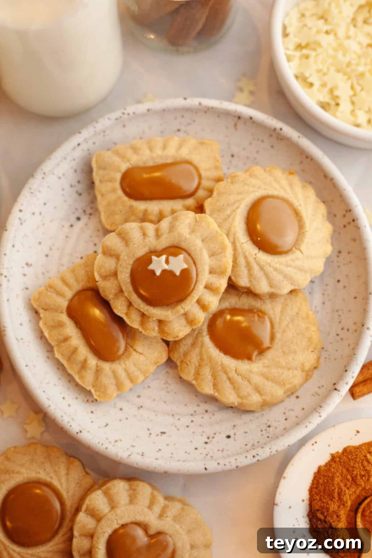 A delightful arrangement of cinnamon shortbread cookies, each boasting a creamy Biscoff center, displayed on a small plate.
