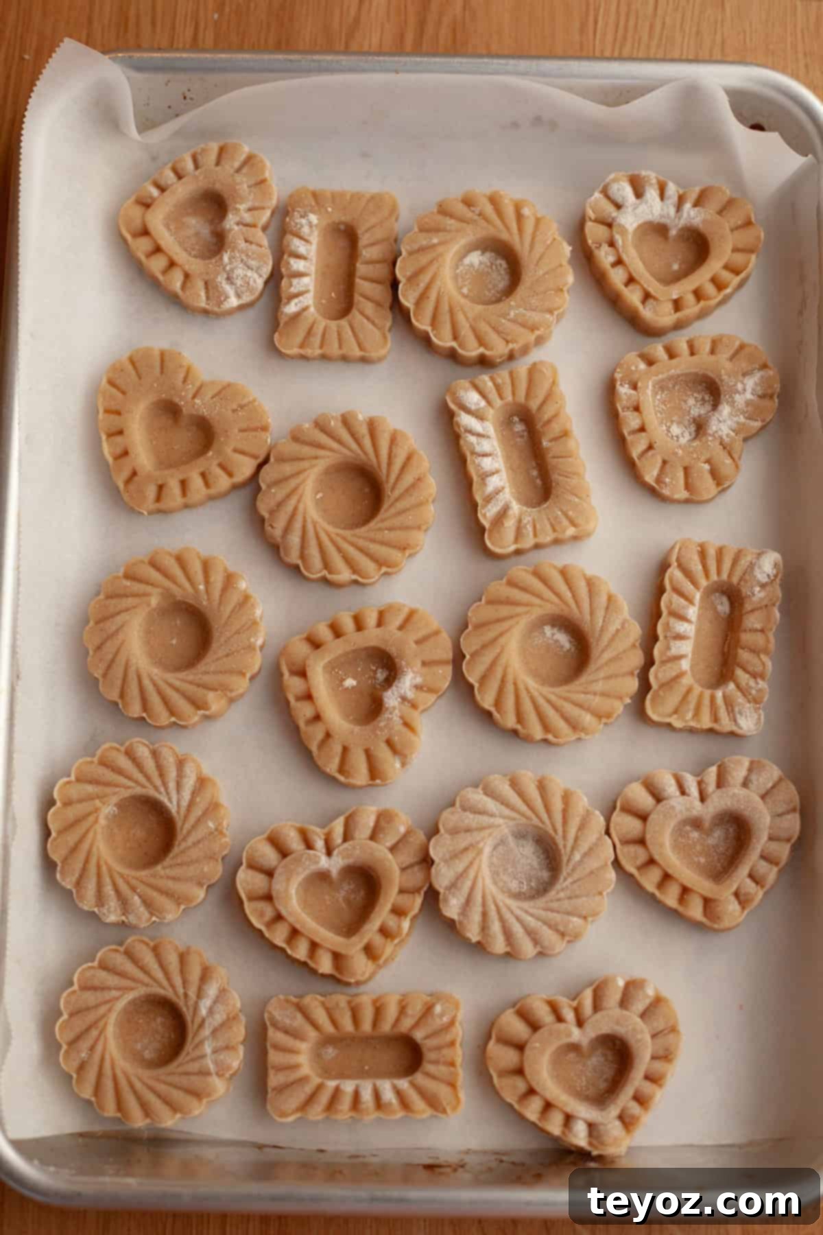 An enticing view of unbaked cinnamon shortbread cookies, neatly arranged on parchment paper, awaiting their transformation in the oven.