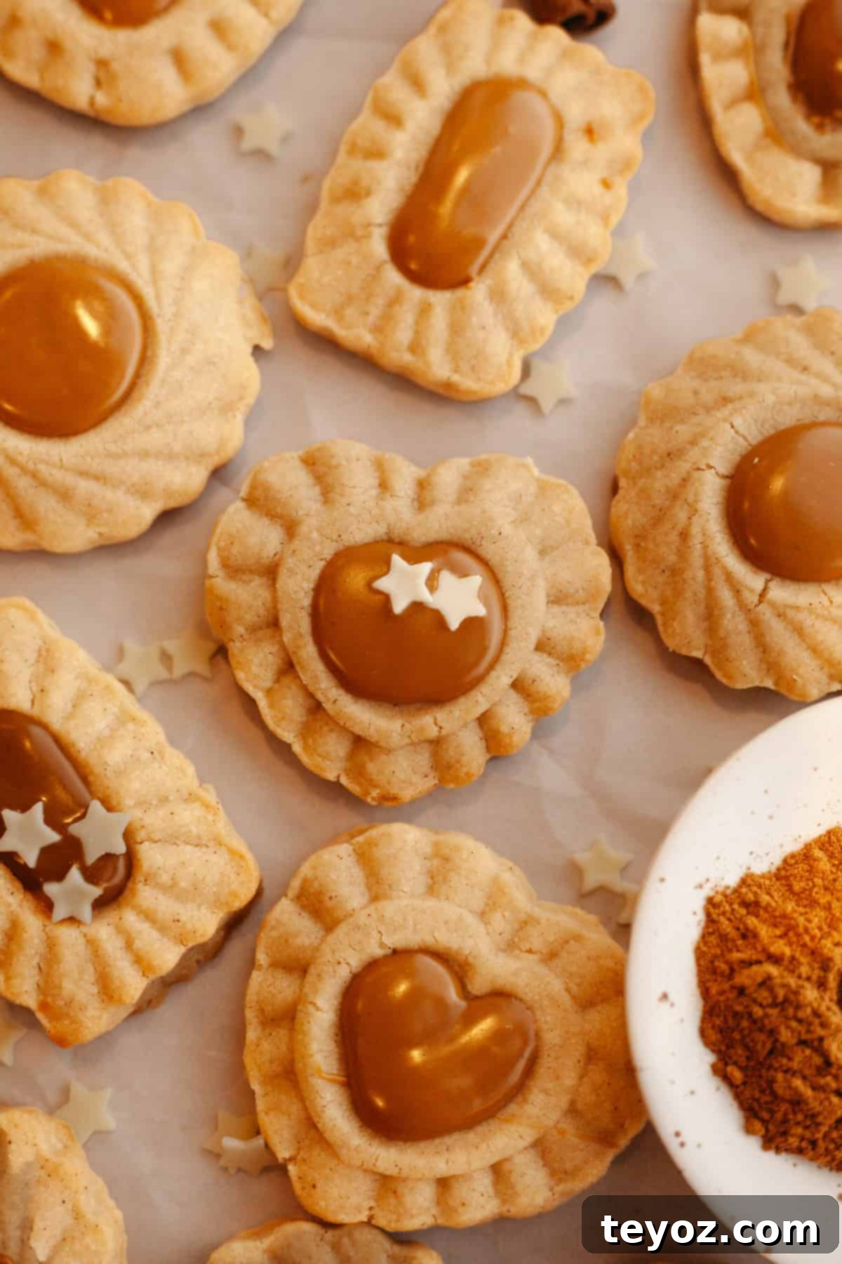 An inviting display of cinnamon cookies adorned with Biscoff middles, resting on parchment paper, showcasing the final touch to these delectable treats.